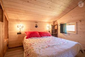 ein Schlafzimmer mit einem Bett in einer Holzhütte in der Unterkunft Les inseparables in Saint-Pierre-de-Curtille