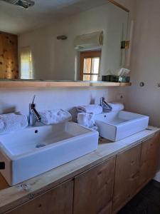 un bagno con due lavandini e un grande specchio di Tiroler Knusperhäuschen a Tannheim