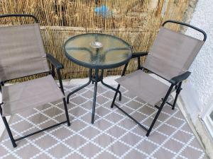 twee stoelen en een glazen tafel en een tafel en stoelen bij Konstantinos Loft in Serres
