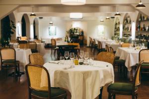 een restaurant met witte tafels en stoelen met glazen bij Auberge du Rédier - Logis Hôtels in Colomars