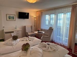 a hotel room with two beds and a table and chairs at Pension Seeblick in Seebruck
