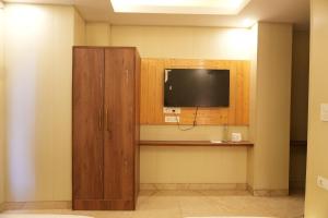 a room with a tv and a wooden cabinet at Sufi Stay in Rishīkesh