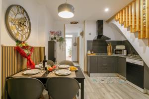 a kitchen with a table with chairs and a clock on the wall at Casita Santa Bárbara - Alicante in Alicante