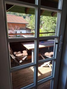 una vista attraverso una finestra di tavolo e sedie di Tiroler Knusperhäuschen a Tannheim Altre 6 foto