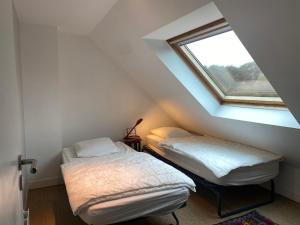 2 letti in una camera mansardata con finestra di Maison récente 4 chambres, vue mer, jardin, 8 pers - FR-1-418-13 a Locmaria