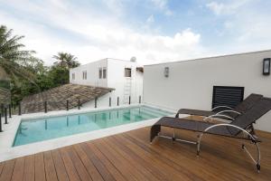 una casa con piscina e terrazza con sedie di Jubarte Flats a Itacaré
