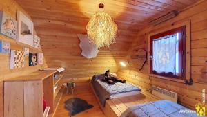 een kat liggend op een bed in een houten kamer bij Chalet de Cécile 1 in Besse-et-Saint-Anastaise