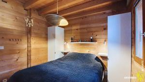 een slaapkamer met een bed in een houten kamer bij Chalet de Cécile 1 in Besse-et-Saint-Anastaise +9 foto's