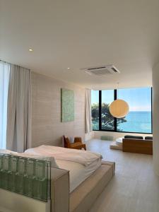 En eller flere senge i et værelse på PORTRAIT Bangsaen - Private Serviced Seaview Pool Villa