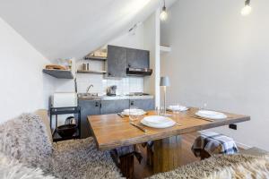 ein Esszimmer mit einem Holztisch und einer Küche in der Unterkunft Hostdomus-La casa di Luna in Grange Sises