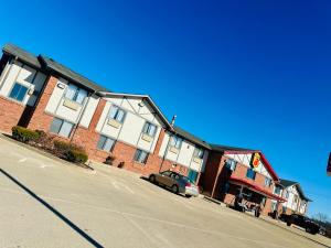 a building with a car parked next to a street at Super 8 by Wyndham Warrenton in Warrenton