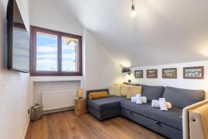 un salon avec un canapé bleu et une fenêtre dans l'établissement Hostdomus-La casa di Luna, à Grange Sises