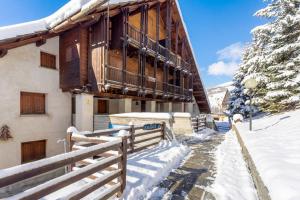 un immeuble avec un balcon sous la neige dans l'établissement Hostdomus-La casa di Luna, à Grange Sises