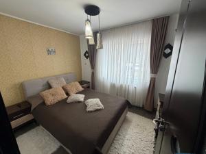 una camera da letto con un letto con cuscini e una finestra di Ingrid home 3 camere a Vatra Dornei