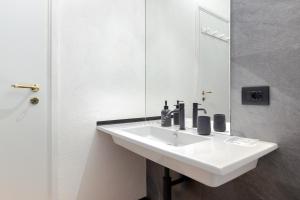 une salle de bains avec un lavabo blanc et un miroir dans l'établissement Hostdomus-La casa di Luna, à Grange Sises 19 autres photos