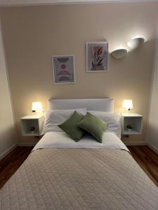 ein Schlafzimmer mit einem Bett mit zwei Kissen und zwei Lampen in der Unterkunft Il Rifugio in Sulmona
