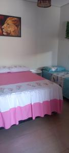 een slaapkamer met een bed met een roze en witte deken bij Lar doce lar in Bonito