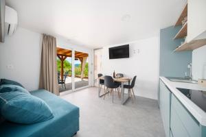 a living room with a blue couch and a table at Mobile Home Kapo I Exclusive Mobile Home with Private Pool in Sitno Donje