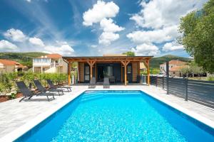 a swimming pool with chairs and a house at Mobile Home Kapo I Exclusive Mobile Home with Private Pool in Sitno Donje