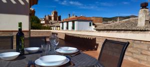 een tafel met witte borden en een fles wijn bij El Balcón de Huéscar in Huéscar