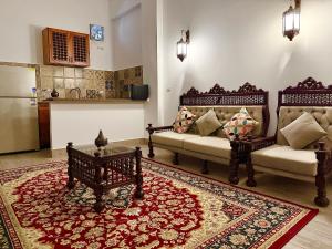 een woonkamer met 2 banken en een tapijt bij Bab Al Shams Palace in Luxor