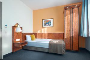 a hotel room with a bed and a door at Trip Inn Hotel Minerva Frankfurt in Frankfurt/Main +17 photos