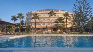 a hotel with a swimming pool in front of a building at Regina Hotel in Kissamos