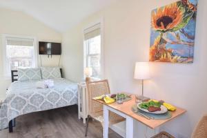 een slaapkamer met een bed en een tafel met een bord eten bij 4 Min Drive to Bayside Beaches in Eastham