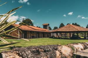 a house with a log in front of it at Pousada refúgio do lago in Lages