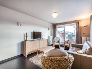 a living room with a couch and a tv at Le Penthouse in Koksijde