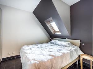 a bedroom with a bed and a skylight at Le Penthouse in Koksijde
