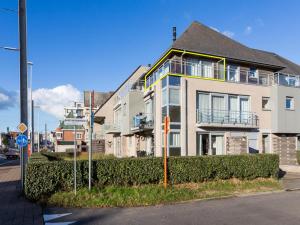 a large white house with a balcony on a street at Le Penthouse in Koksijde