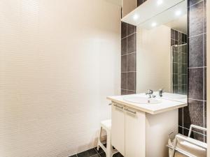 a bathroom with a sink and a mirror at Le Penthouse in Koksijde +10 photos