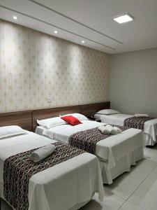 una stanza con tre letti in una stanza di Pousada Lagoa Seca a Juazeiro do Norte