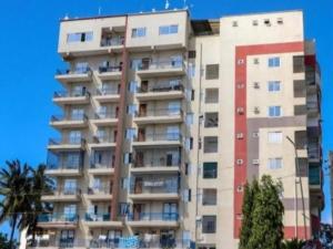 a tall apartment building with a red stripe on it at Cozy studio at Kisimani Heights Apartment Mombasa in Mombasa