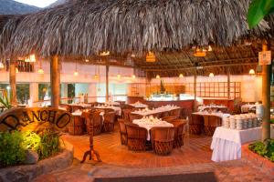 a dining room with tables and chairs in a restaurant at Decameron Galeon - All Inclusive in Santa Marta