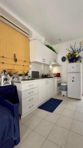 una cucina con mobili bianchi e un frigorifero bianco di Fay's paradise a Polykhrono