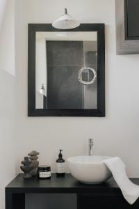 ein Badezimmer mit einem weißen Waschbecken und einem Spiegel in der Unterkunft Matador Lodges in Grabenstätt