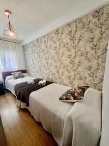 een slaapkamer met twee bedden en een muurschildering bij ALCALA LUXURY piso de 80m con 3 habitaciones 2 baños y terraza in Alcalá de Henares