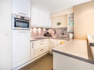 a kitchen with white cabinets and a white refrigerator at Anais derde in Sint-Idesbald