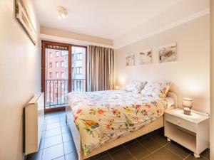 a small bedroom with a bed and a window at Anais derde in Sint-Idesbald