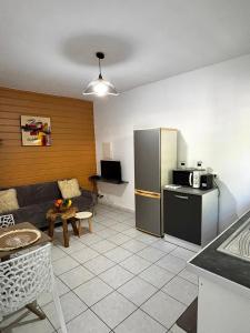 een keuken met een bank en een koelkast in een kamer bij La bulle D'Isma - Jacuzzi intimiste, proche plage in Le Gosier