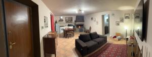 een woonkamer met een bank en een keuken bij Domus Gavazzano in Viterbo