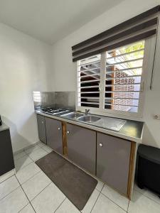 a kitchen with a sink and a window at La bulle D'Isma - Jacuzzi intimiste, proche plage in Le Gosier +11 photos