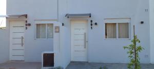 ein weißes Gebäude mit zwei Türen und einem Fenster in der Unterkunft Departamento NAMASTE I in Carhué + 6 Fotos