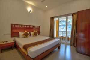ein Schlafzimmer mit einem großen Bett und einem großen Fenster in der Unterkunft Goa Radha Krishna holiday in Calangute + 12 Fotos