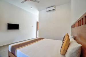 a bedroom with a bed with a yellow pillow at Goa Radha Krishna holiday in Calangute