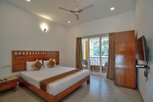 ein Schlafzimmer mit einem großen Bett und einem Fernseher in der Unterkunft Goa Radha Krishna holiday in Calangute