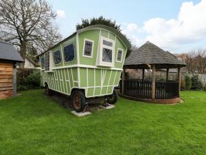 a tiny house parked in a yard next to a gazebo at The Gypsy Caravan in Marlborough