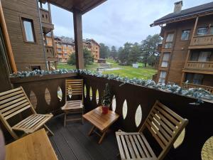 deux chaises et une table sur un balcon avec vue dans l'établissement Pirin Golf Cozy Studio, à Razlog